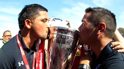Miguel Riffo besando la copa de campeón del Clausura 2014 junto a Héctor Tapia.