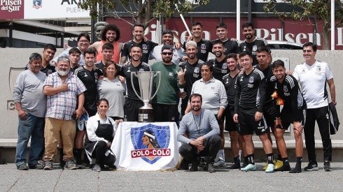 Funcionarios de Colo Colo celebran con el trofeo de campeones.